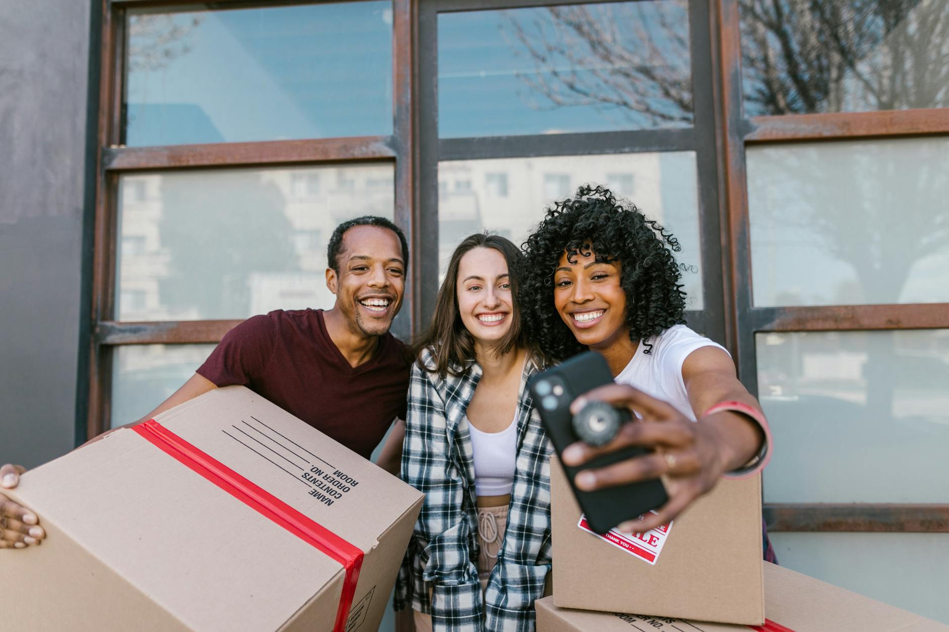 man and woman smiling while holding box